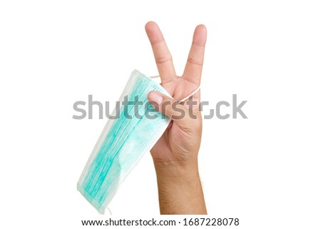 Doctor hands put V sign holding disposable surgical mask on white background. concept Healthy. Victory sign.