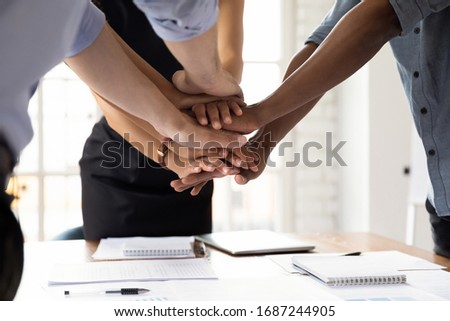 Close up diverse businesspeople stacked their palms together showing support amity and loyalty. Concept of business team unity, common project, start important negotiations mate encouraging each other Royalty-Free Stock Photo #1687244905