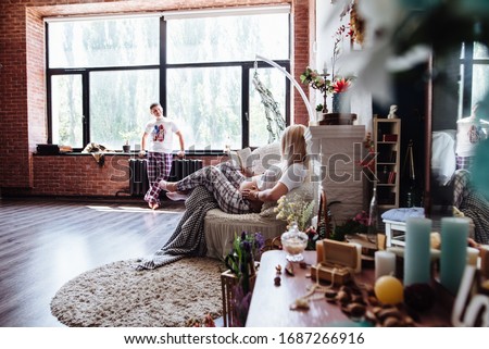 Pregnant woman reading a book in the living room lying on the couch. A young, expectant mother is reading a book on pregnancy and childbirth. Concept of pregnancy, motherhood, rest, expectation.