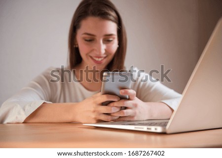 Portrait of a young woman using her smart phone. Typing with both her hands