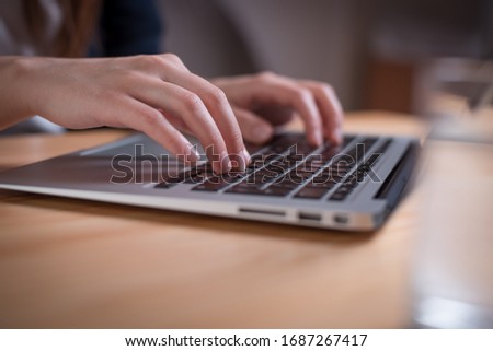 Close up of a woman hands working on a laptop computer from her home
