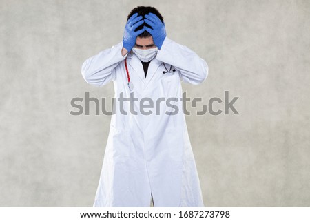  a doctor in protective clothing grabs his head