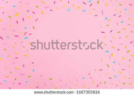 Sweet colorful confetti on pastel pink background. Minimal trendy composition. Birthday party, celebration, mockup for design. Top view, frame, flat lay, copy space