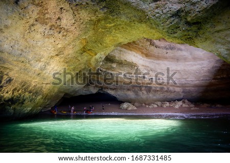 A picture of Benagil cave taken from a boat with a view of light coming from the hole up in the cave