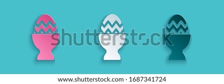 Paper cut Easter egg on a stand icon isolated on blue background. Happy Easter. Paper art style. Vector Illustration