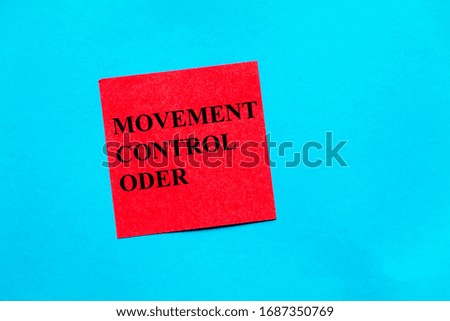 Movement control order word written on red color note pad on blue background. 