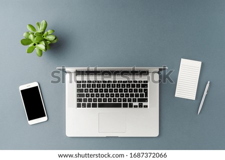 Laptop on gray background with business accessories. Office desktop. Top view