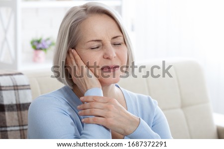 Tinnitus. Closeup up side profile sick female having ear pain touching her painful head. Concept photo with indicating location of the pain. Health care concept Royalty-Free Stock Photo #1687372291