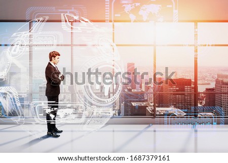 Confident young businessman standing in panoramic office with double exposure of blurry futuristic business interface. Concept of hi tech and leadership. Toned image