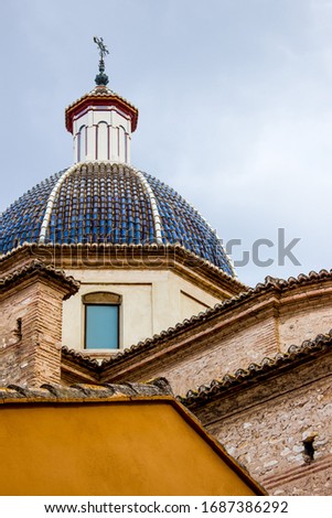 roof of old spanish church with cross, background with historical building