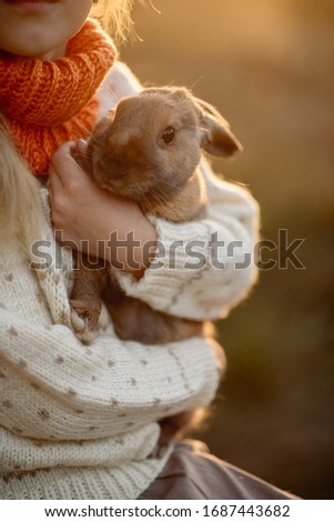 Cute easter bunny - rural style, in nature, children play with a rabbit
