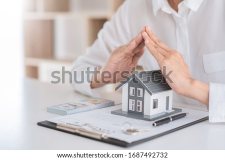 insurance protective hand over house for protection and care, Concept of home and real estate Property insurance Royalty-Free Stock Photo #1687492732