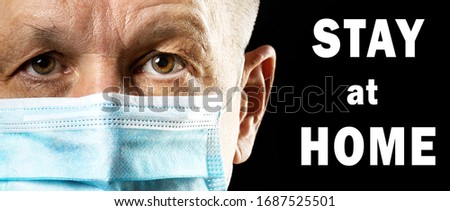 Stay at home. Coronavirus Covid-19, quarantine motivational phrase. Man in medical mask looking at camera on black background with title. Coronavirus Covid-19 non-proliferation measures 