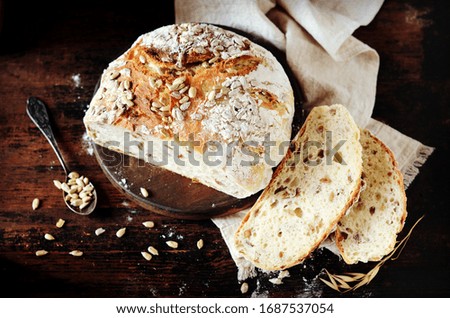 Homemade bread with sunflower seeds on a dark wooden background