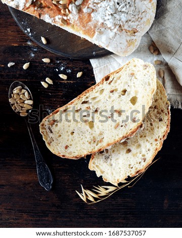 Homemade bread with sunflower seeds on a dark wooden background