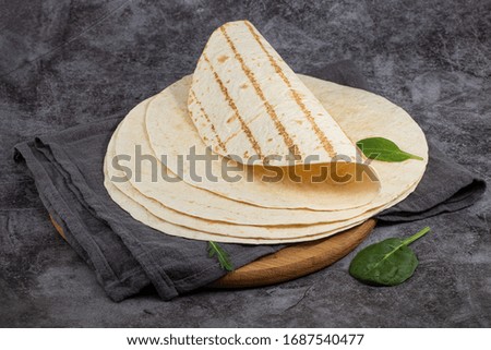 Stack of corn tortillas on dark background. Mexican food.