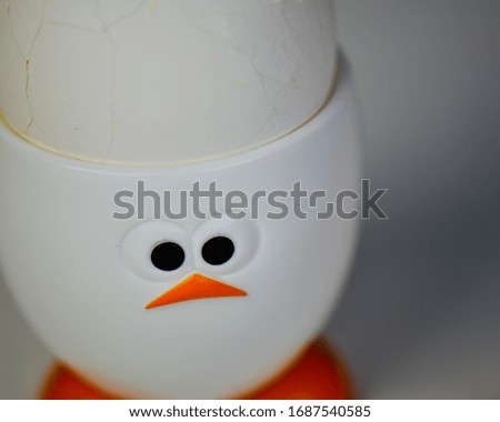 cracked hard boiled egg in a white chicken egg cup