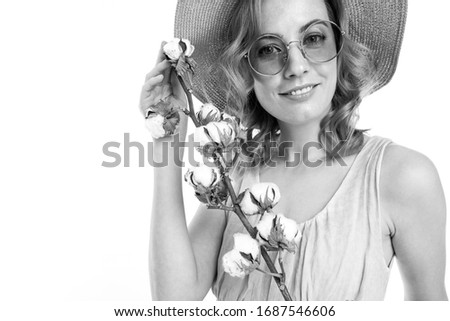 Cheerful woman with fair red hair in beautiful dress holds a perfect flower, black and white picture isolated on white background