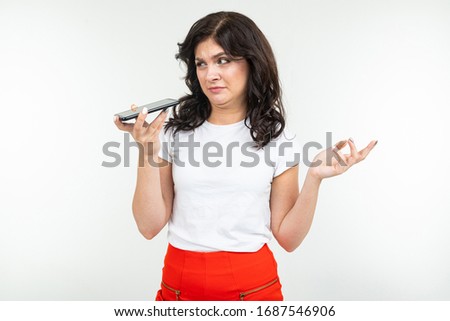 brunette woman talking on the phone handsfree on an isolated white background