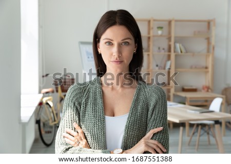 Headshot portrait of confident young Caucasian businesswoman look at camera posing in modern office, motivated millennial European female CEO or boss show leadership and success in career Royalty-Free Stock Photo #1687551388