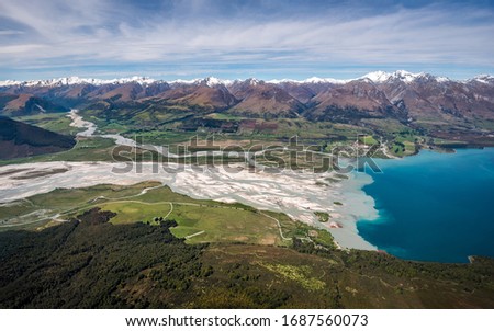 Aerial drone photo of Glenorchy, Lake Wakatipu, Dart river and Rees river formations in beautiful valley sorrounded by Mount Aspiring National Park snowy moutains. View from helicopter or airplane.