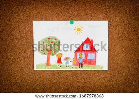 Drawing of a happy family and an apple tree and a house pinned on to cork board. Close up. 