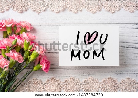 Design concept - top view of bunch of beautiful carnation with greeting card and handwriting calligraphy on white vintage wooden background for mother day mockup