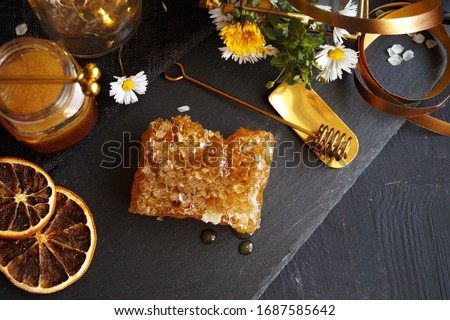 Honeycomb with delicious honey on black background               