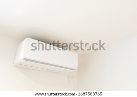 White color air conditioner machine isolated on white wall background with copy space.