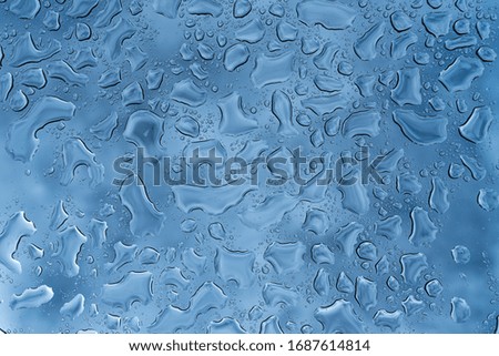 Water rain drops or water drops on glass with  sky background