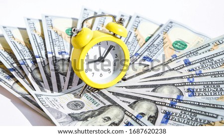 business financial ideas concept with banknotes stack and alarm clock background with free copy space for creativity text. time is money. time is worth the money. time is more valuable than money, 100