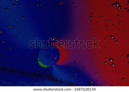 Macro photography of water and oil with rainbow colors and artificial lighting.