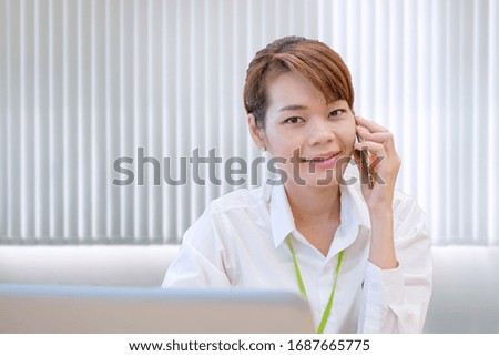 Smiling modern young asian business woman working with laptop at workplace 