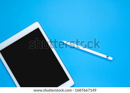 tablet with pen isolated on blue background, technology concept