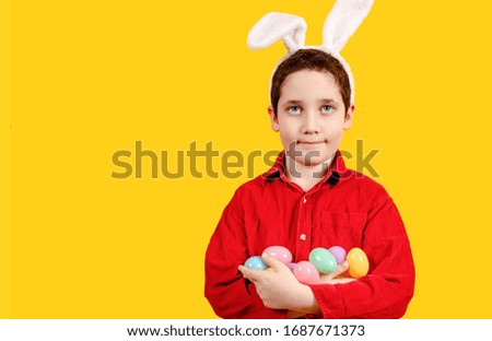Glorious boy in bunny ears headband holding Golden Easter eggs