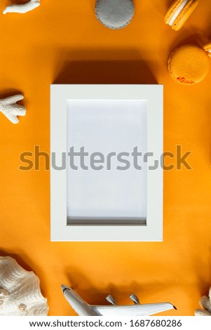 Top view of tasty orange yellow macarons and blank picture. Concepts ideas background on yellow paper, flatlay and copy Space. Using for Mock up template for display of your design.