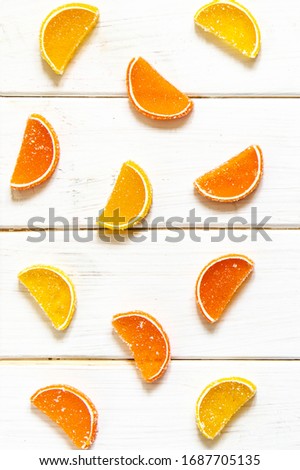 Multicolored fruit marmalade rests on a white wooden background