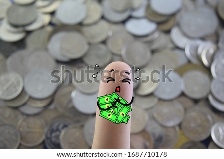 One finger is decorated as a man. He is hugging a lot of cash money . He is crying sadly.