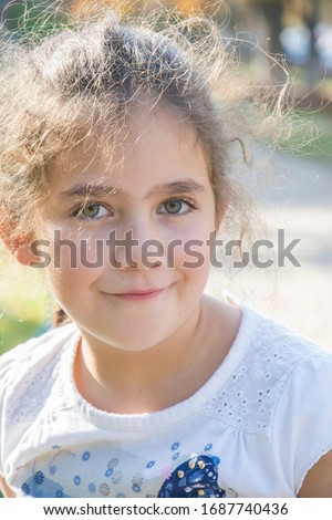 On the street is a little beautiful girl. Close-up.