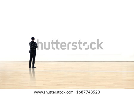 Businessman watching  blank space wall in modern gallery, Art exhibition minimal concept, 