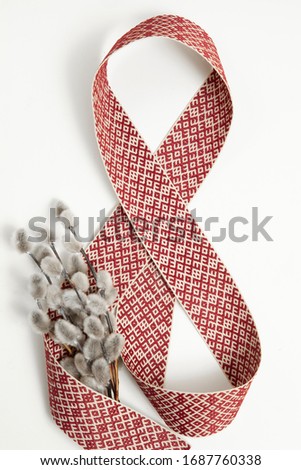 Creative image depicting traditional conception of health care on Palm Sunday in Latvia. Bunch of pussy willows wrapped in belt with latvian signs and symbols
