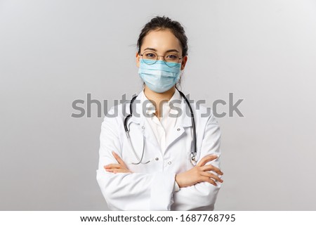 Covid19, coronavirus, healthcare and doctors concept. Portrait of professional confident young asian doctor in medical mask and white coat, stethoscope over neck, ready help patient, fight disease Royalty-Free Stock Photo #1687768795