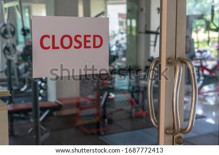 Closed sign on a glass of the door in gym due to Covid-19 or Corona virus outbreak pandemic crisis. 