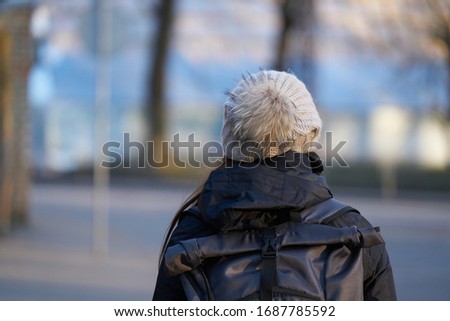 woman view from back, dressed in knitted hat with pompom. Royalty-Free Stock Photo #1687785592