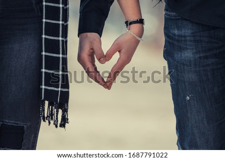 Closeup of couple making heart shape with hands
