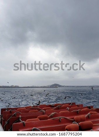 a picture of a ship sailing to an island in bad weather.