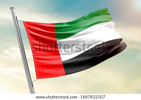 United Arab Emirates national flag cloth fabric waving on the sky with beautiful sun light - Image