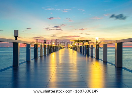 Nature background with sunset and sky at twilight. Perspective of wood bridge, pavilion and tile floor. Asia travel destination in Chonburi of Thailand called Bangsaen Beach for holiday and vacation.