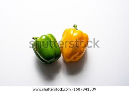 Stock photo of a green and a yellow pepper on a white background