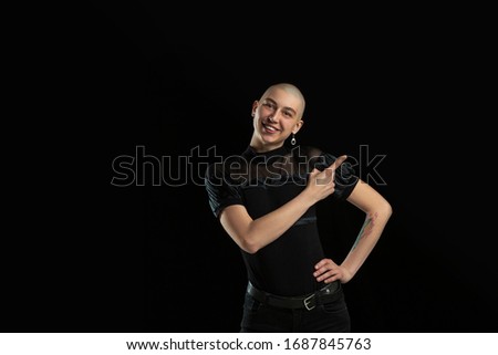 Showing something. Monochrome portrait of young caucasian bald woman isolated on black studio background. Beautiful female model. Human emotions, facial expression, sales, ad concept. Youth culture.